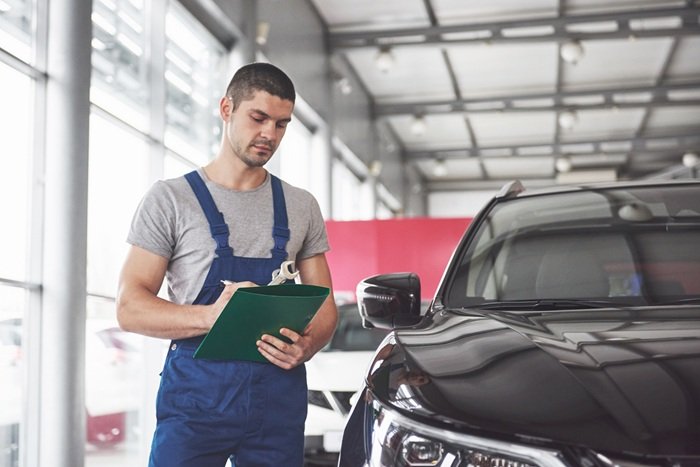 Professional mechanic going over a checklist for buying a second hand car