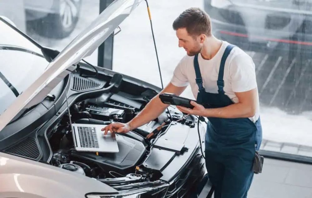 Professional mechanic helping to check used car condition accurately