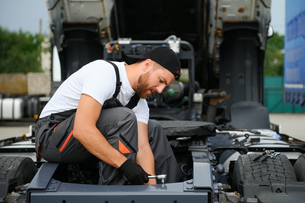 Professional buyer loading a car with transmission problems onto a flatbed truck safely